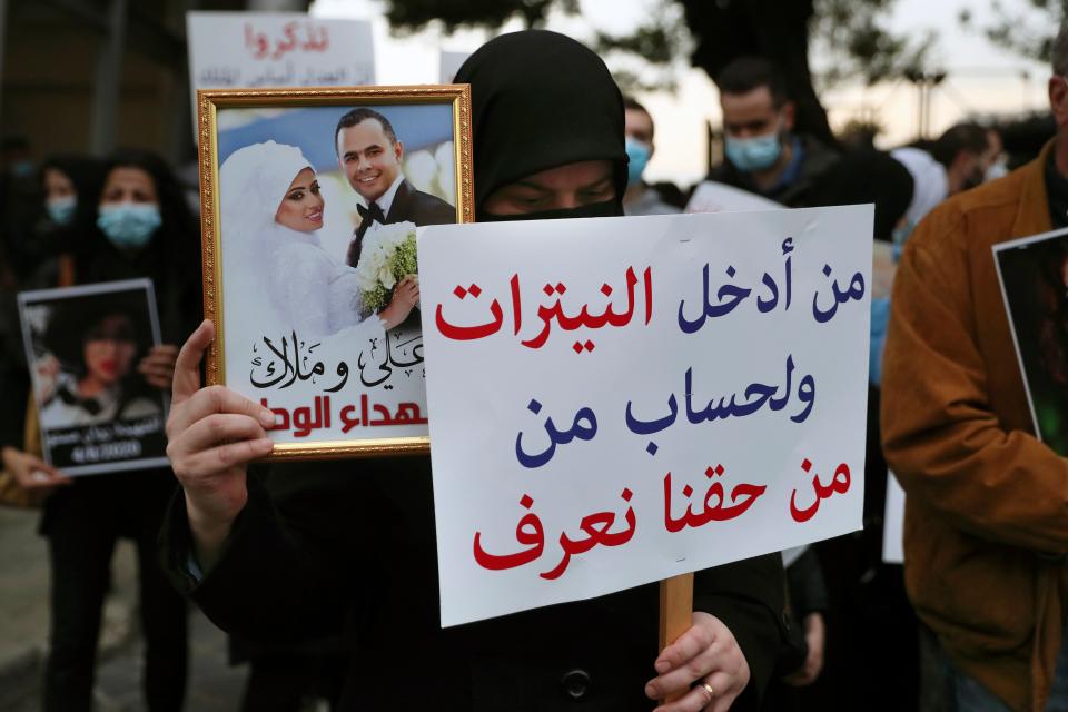 Relatives in Beirut hold portraits of the victims six months on from the blastAP