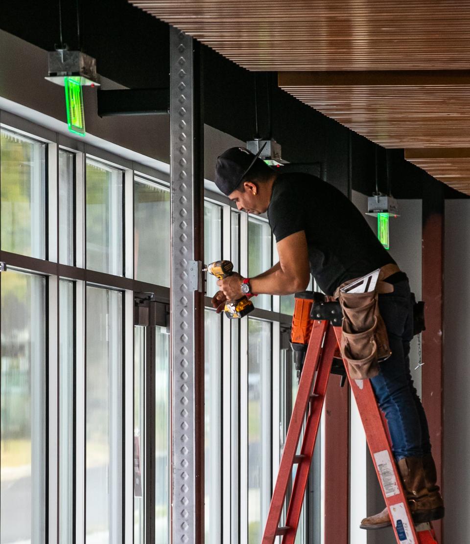 A construction worker attaches metal studs to a steel beam in the new lobby as workers were putting on the finishing touches on the Reilly Arts Center on Dec. 9.