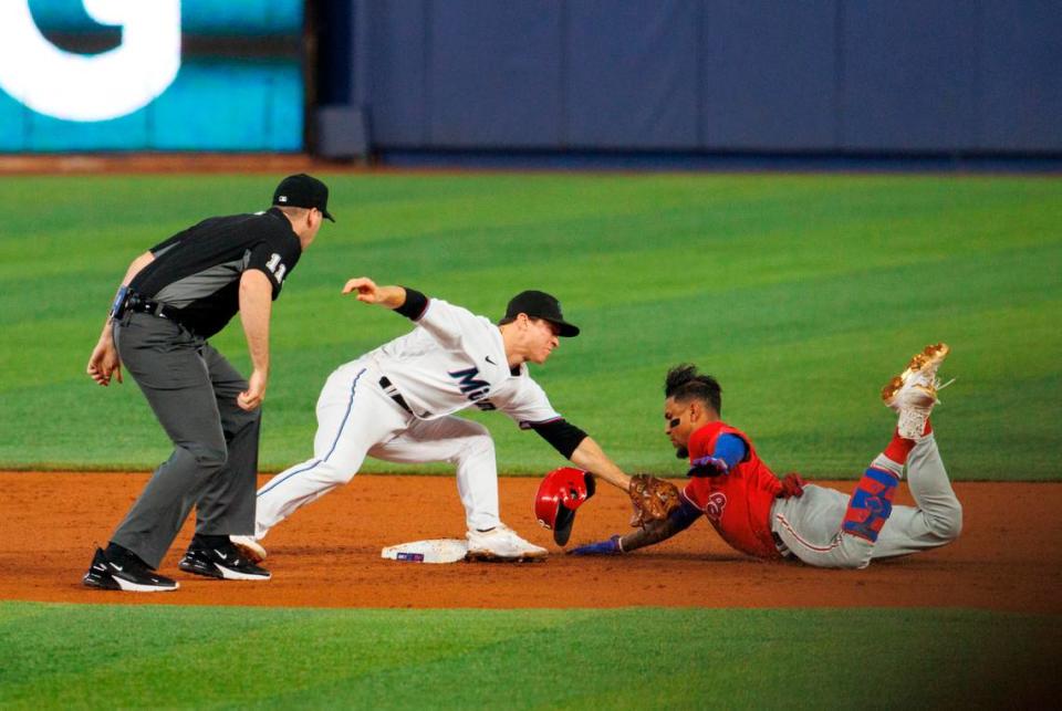 Philadelphia Phillies first baseman Johan Camargo (7) slides as Miami Marlins second baseman Joey Wendle (18) applying a tag for an out during the third inning of a baseball game at LoanDepot Park on Sunday, July 17, 2022 in Miami, Florida.