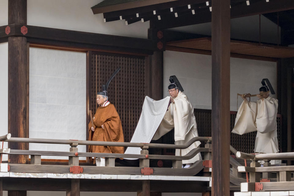 In this photo provided by the Imperial Household Agency of Japan, Japan's Emperor Akihito, left, walks for a ritual to report his abdication to the throne, at the Imperial Palace in Tokyo, Tuesday, April 30, 2019. The 85-year-old Akihito ends his three-decade reign on Tuesday when he abdicates to his son Crown Prince Naruhito. (The Imperial Household Agency of Japan via AP)