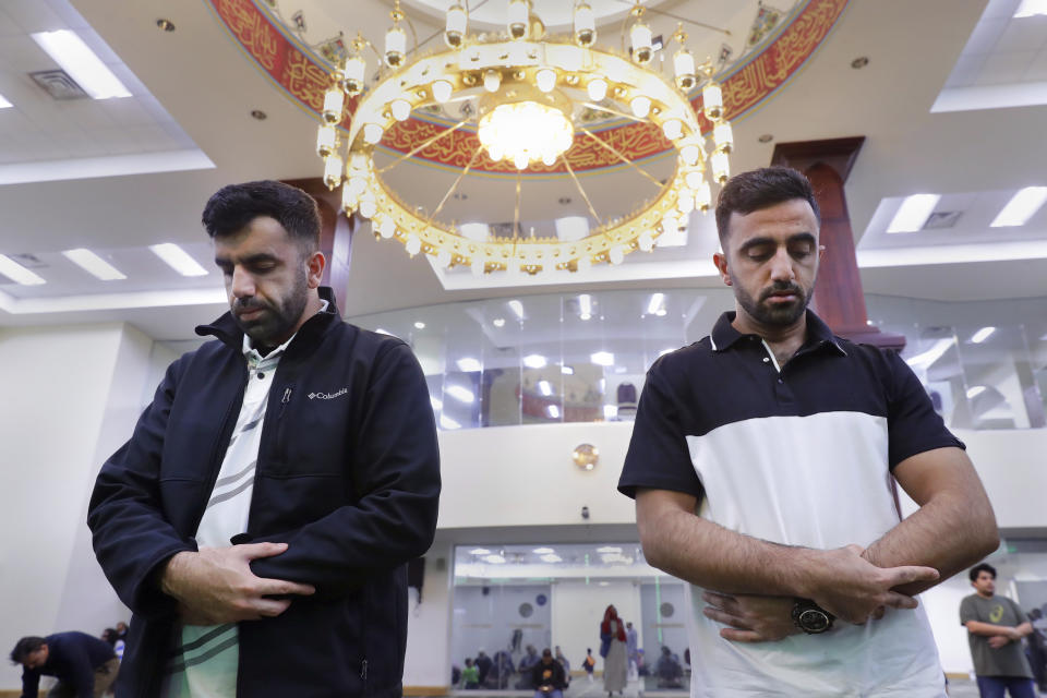 Brothers Samiullah Safi, left, and Abdul Wasi Safi pray during Friday prayers at the Al-Noor Society Mosque in Houston, on April 7, 2023. Abdul, who had suffered injuries while assisting the U.S. military in Afghanistan during the war, has recently arrived in Houston after being detained for months, but has no documentation allowing him to begin a normal life with his brother Samiullah. (AP Photo/Michael Wyke)