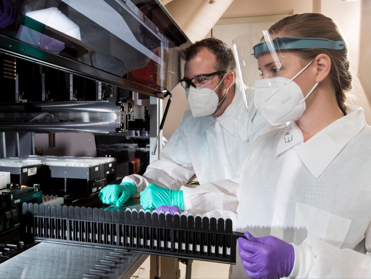 In this Wednesday 22 July 2020, photo provided by C2N Diagnostics, Matthew Meyer, left, senior proteomics scientist, and Stephanie Knapik, a research associate, work in a lab that analyzes blood samples at the company’s facility in the Center for Emerging Technologies in St Louis ((Associated Press))