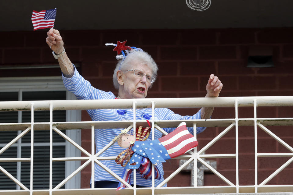 FILE - In this March 20, 2020 file photo, a resident of the Lambeth House, where a cluster of the coronavirus has formed, reacts from her balcony as opera singers Irini Hymel and Bryan Hymel sing to the quarantined residents in New Orleans. Where political divides marred early recovery efforts after Hurricane Katrina in 2005, Louisiana is showing rare political unity in the fight against the new coronavirus. (AP Photo/Gerald Herbert, File)