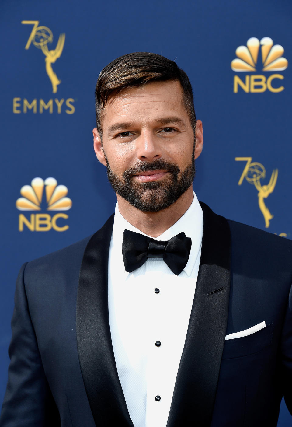 Man in a bow tie and tuxedo posing at the Emmys event