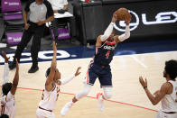 Washington Wizards guard Russell Westbrook (4) leaps up to pass the ball from between Cleveland Cavaliers center Jarrett Allen, right, forward Isaac Okoro, second from left, and guard Darius Garland, left, during the first half of an NBA basketball game Friday, May 14, 2021, in Washington. (AP Photo/Nick Wass)