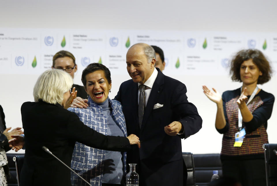 FILE - In this Dec. 12, 2015 file photo, French foreign minister and President of the COP21 Laurent Fabius, center, hugs France's Laurence Tubiana, special representative for the COP21, left, and United Nations climate chief Christiana Figueres after the final conference of the COP21, the United Nations conference on climate change, in Le Bourget, north of Paris. The international effort to fight climate change is about to get injected with a bit of Hollywood flash, a lot of Wall Street green and a considerable dose of cheerleading rather than dry treaty negotiations. Business leaders, mayors, governors and activists from around the world gather Wednesday, Sept. 12, 2018, in San Francisco for the Global Climate Action Summit, where participants will trumpet what they’ve done and announce new efforts to slow a warming world. (AP Photo/Francois Mori, File)