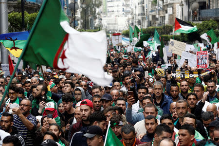 Demonstrators hold flags and banners as they return to the streets to press demands for wholesale democratic change well beyond former president Abdelaziz Bouteflika's resignation, in Algiers, Algeria April 19, 2019. REUTERS/Ramzi Boudina