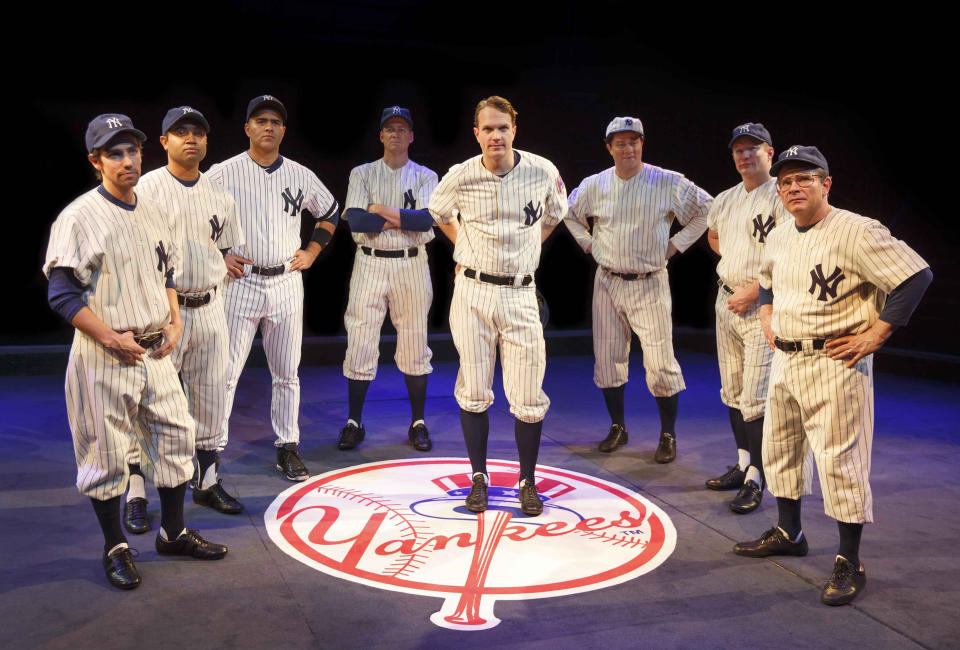 This image released by Polk & Co. Peter Scolari, portraying baseball legend Yogi Berra, right, and the cast from the play, "Bronx Bombers," which examines the rich history of the New York Yankees. (AP Photo/Polk & Co., Joan Marcus)