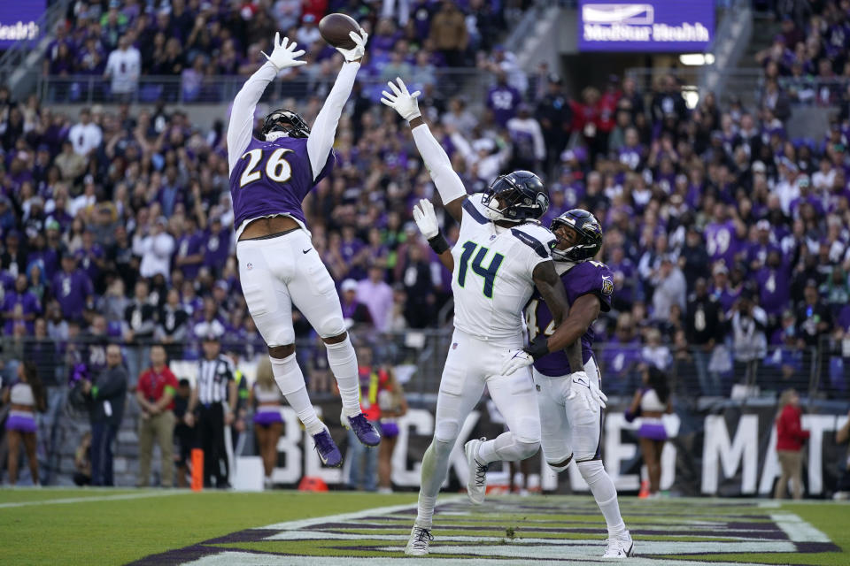 Baltimore Ravens safety Geno Stone (26) and cornerback Marlon Humphrey, right, break up a pass intended for Seattle Seahawks wide receiver DK Metcalf (14) during the second half of an NFL football game, Sunday, Nov. 5, 2023, in Baltimore. (AP Photo/Alex Brandon)