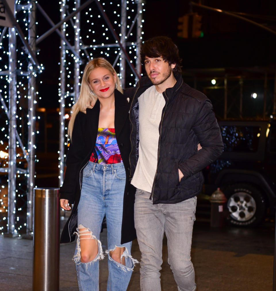 The couple walking together outside at night