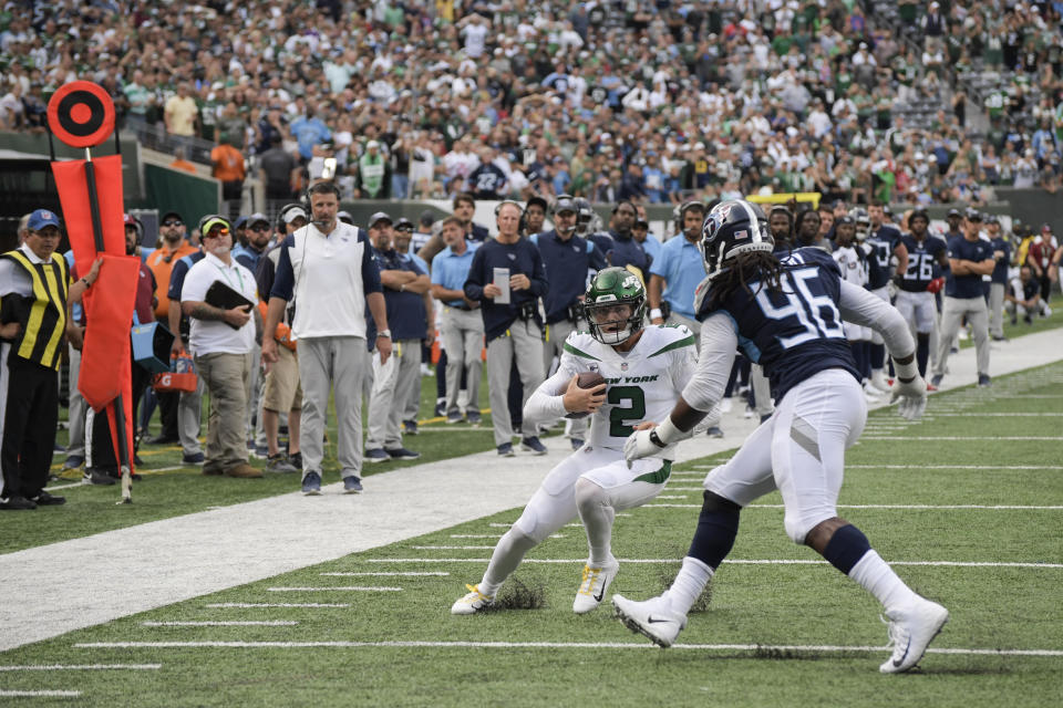 New York Jets quarterback Zach Wilson (2) runs the ball against Tennessee Titans defensive end Denico Autry (96) during overtime of an NFL football game, Sunday, Oct. 3, 2021, in East Rutherford, N.J. (AP Photo/Bill Kostroun)