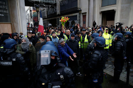 Protesters wearing yellow vests face off with French Gendarmes during a national day of protest by the "yellow vests" movement in Paris, France, December 8, 2018. REUTERS/Stephane Mahe