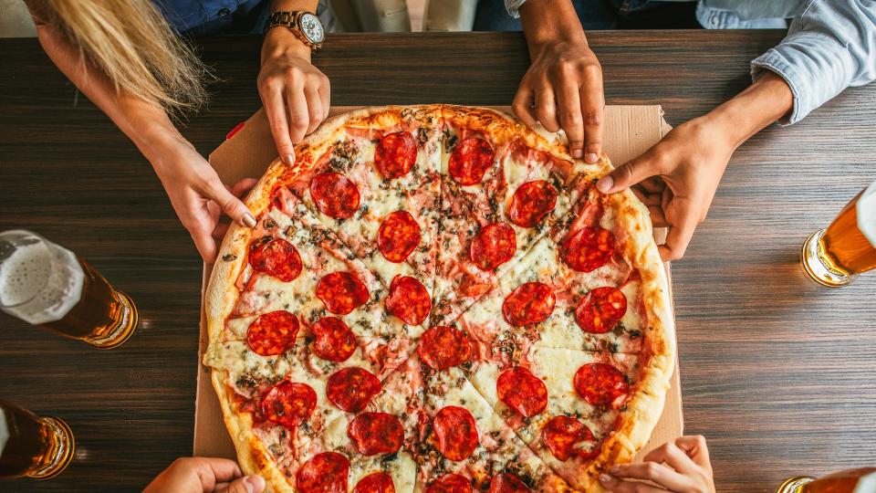 friends eating pizza together for National Pi Day