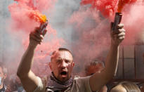 People, some of them ethnic Belarusians, light flares and wave Belarusian flags to support Belarusian opposition in front of Belarusian Embassy in Kyiv, Ukraine, Friday, Aug. 14, 2020. Crowds of protesters in Belarus swarmed the streets and thousands of workers rallied outside industrial plants to denounce a police crackdown on demonstrations over a disputed election that extended the 26-year rule of authoritarian President Alexander Lukashenko. (AP Photo/Efrem Lukatsky)