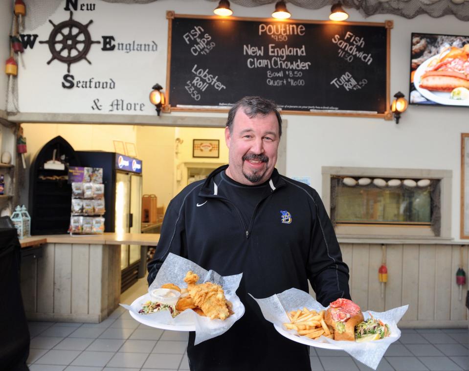 Tom Carlson of New England Seafood at the New England Sports Center in Marlborough, March 2, 2022, with fish 'n' chips and a lobster roll.