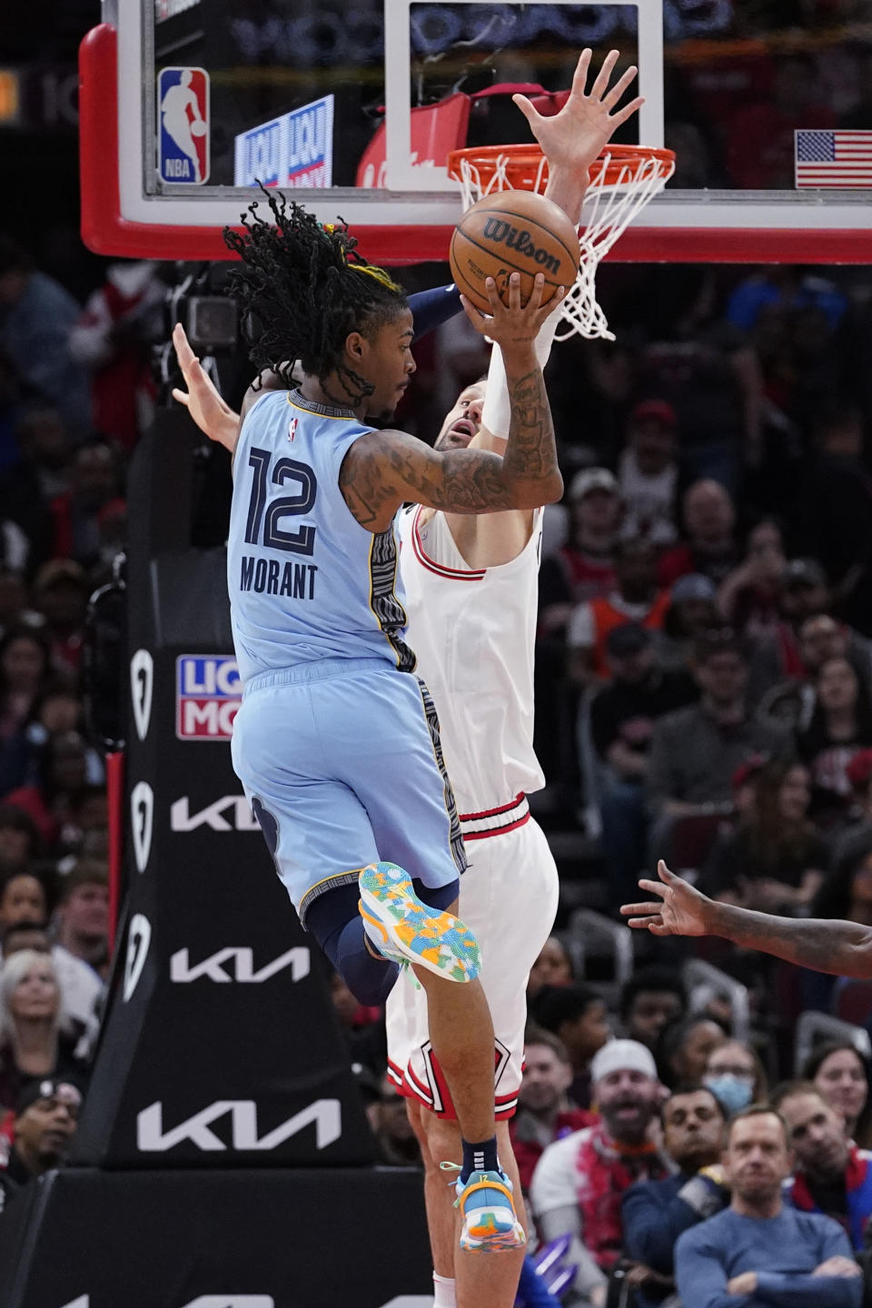 Memphis Grizzlies guard Ja Morant (12) looks to pass as Chicago Bulls center Nikola Vucevic guards during the first half of an NBA basketball game in Chicago, Sunday, April 2, 2023. (AP Photo/Nam Y. Huh)