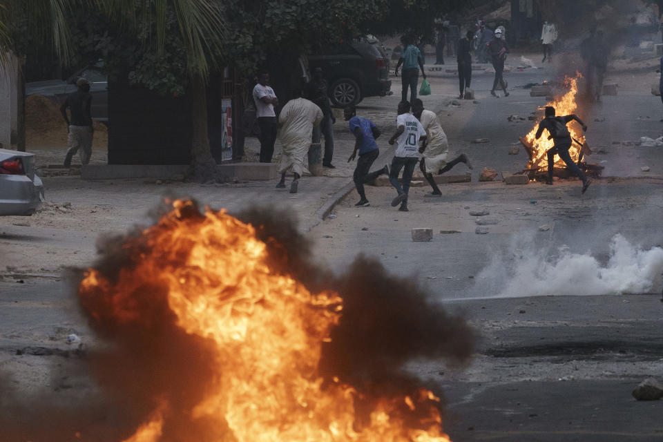 Demonstrators run after police officers fired tear gas during a protest in support of the main opposition leader Ousmane Sonko in Dakar, Senegal, Monday, May 29, 2023. The clashes came a day after police stopped Sonko's "freedom caravan," traveling from his hometown of Ziguinchor, in the south and where he is the mayor, to the capital, Dakar, where he was forced into a home he has in the city. (AP Photo/Leo Correa)