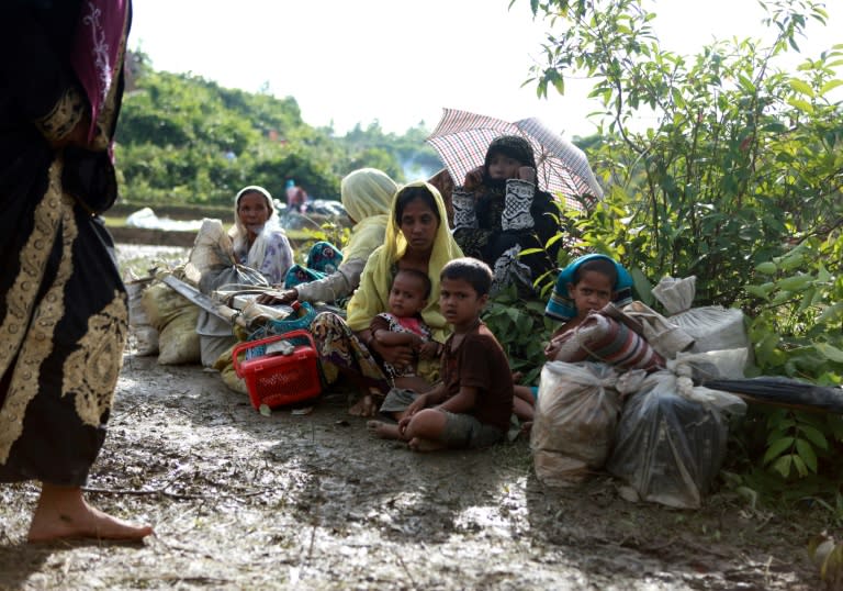 A Rohingya family sit beside a road in Nykkhongchhari, Bangladesh, after fleeing violence in Myanmar