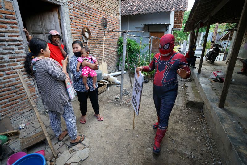 Man donning superhero costume brings cheer to children confined to their homes by COVID-19 restrictions in Sukoharjo