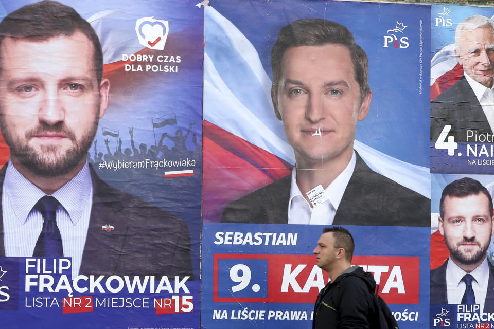 A pedestrian walks past electoral posters in Warsaw, Poland, Monday, Oct. 14, 2019. Nearly complete results in Poland's weekend election confirm that the conservative ruling party Law and Justice capitalized on its popular social spending policies and social conservatism to do better than when it swept to power four years ago. (AP Photo/Czarek Sokolowski)