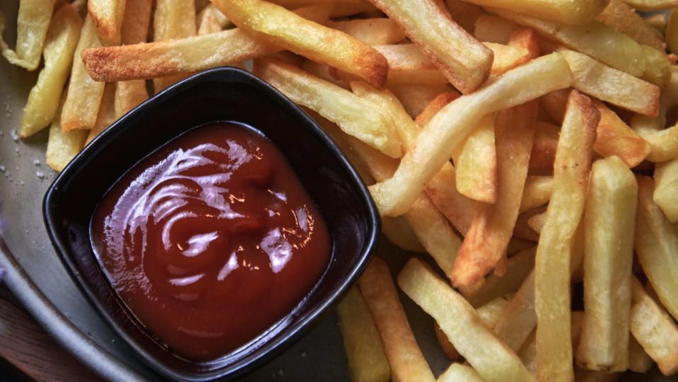 A plate of french fries with a dipping bowl full of ketchup. (Photo via Getty Images)