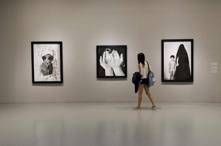 A woman looks at the art of Iranian visual artist Shirin Neshat during the exhibits public opening at the Hirschhorn Art Museum in Washington, DC, May 18, 2015