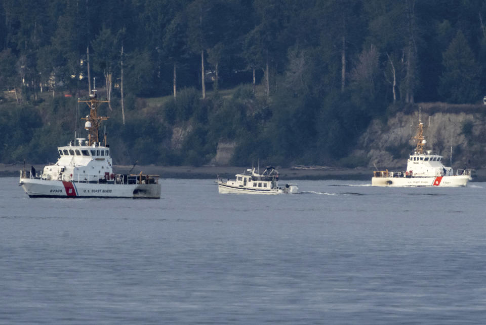 A pair of U.S. Coast Guard vessels search the area, Monday, Sept. 5, 2022, near Freeland, Wash., on Whidbey Island north of Seattle where a chartered floatplane crashed the day before. The plane was en route from Friday Harbor, Wash., to Renton, Wash. (AP Photo/Stephen Brashear)