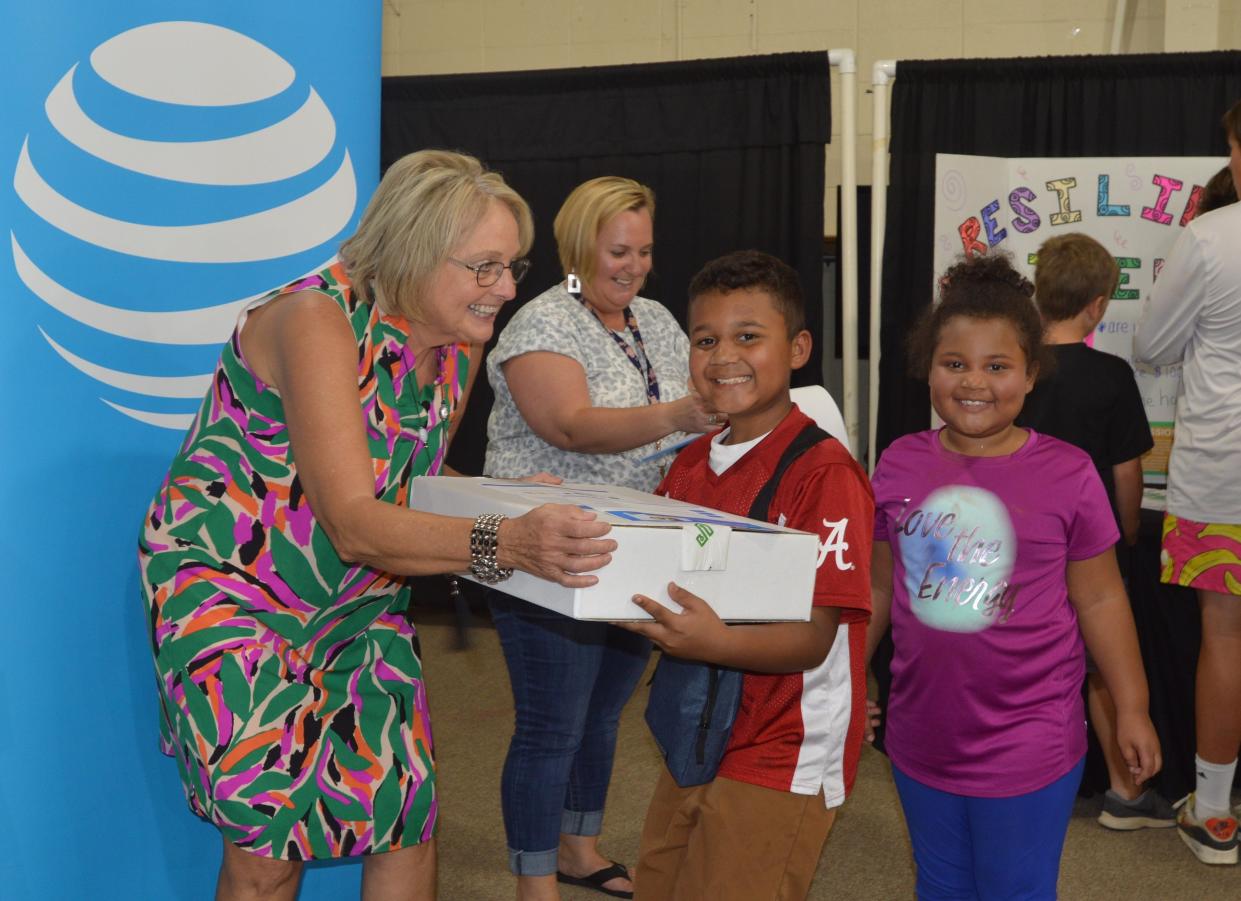 Wanda Davis of Family Connections and Communities in Schools of Glascock County presents a new free laptop computer to one of 75 area families.