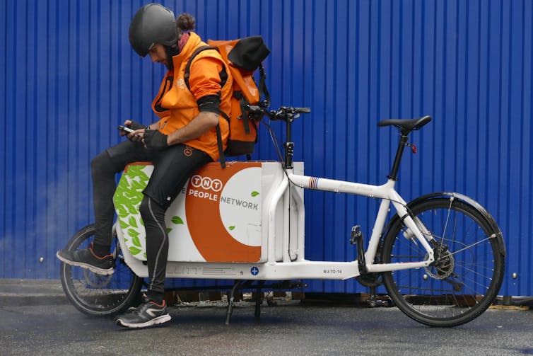 A courier on his cargo bike in Turin, Italy. <a href="https://www.shutterstock.com/image-photo/parcel-delivery-worker-on-his-cargo-751032943" rel="nofollow noopener" target="_blank" data-ylk="slk:Antonello Marangi/Shutterstock;elm:context_link;itc:0;sec:content-canvas" class="link rapid-noclick-resp">Antonello Marangi/Shutterstock</a>