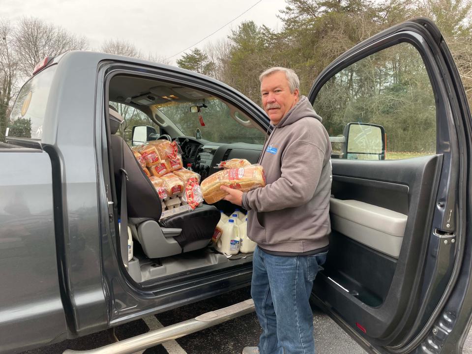 Pastor Barry Mayfield unloads bread, milk, and eggs for the Food Pantry at Center Faith Church Friday, Jan. 21, 2022.