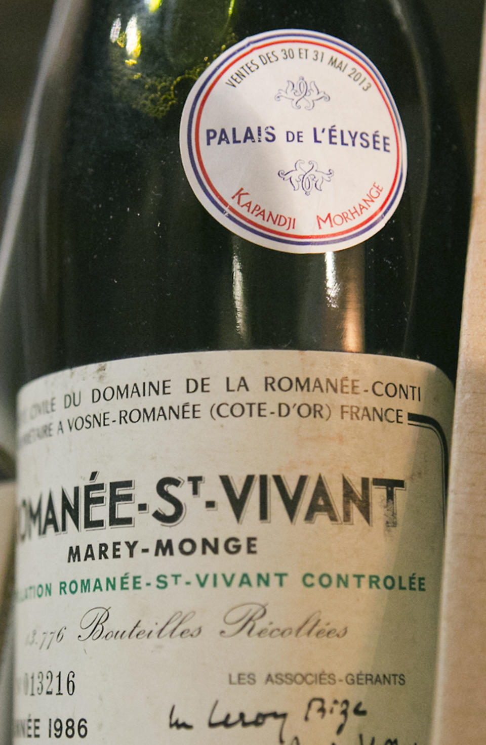 In this photo dated Tuesday May 28, 2013, a bottle of Romanee Saint Vivant 1986 put on auction by the French presidential Palace is pictured during an auction preview in Issy les Moulineaux, south of Paris, France. French President Francois Hollande’s palace has decided to dive into its wine cellar and sell some of its treasures, to raise money and replenish its collection with more modest vintages. About 1,200 bottles, a tenth of the Elysee’s wine collection, are to be sold at Drouot auction house in Paris on Thursday and Friday. (AP Photo/Jacques Brinon)