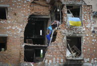 Residents take out their belongings from their house ruined by the Russian shelling in Irpin close to Kyiv, Ukraine, Saturday, May 21, 2022. (AP Photo/Efrem Lukatsky)