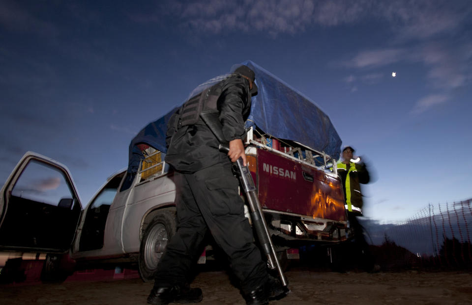 Police inspect a vehicle as they search for escaped drug lord Joaquin "El Chapo" Guzman, around the Almoloya prison in Toluca, Mexico, Sunday, July 12, 2015. (AP Photo/Marco Ugarte)