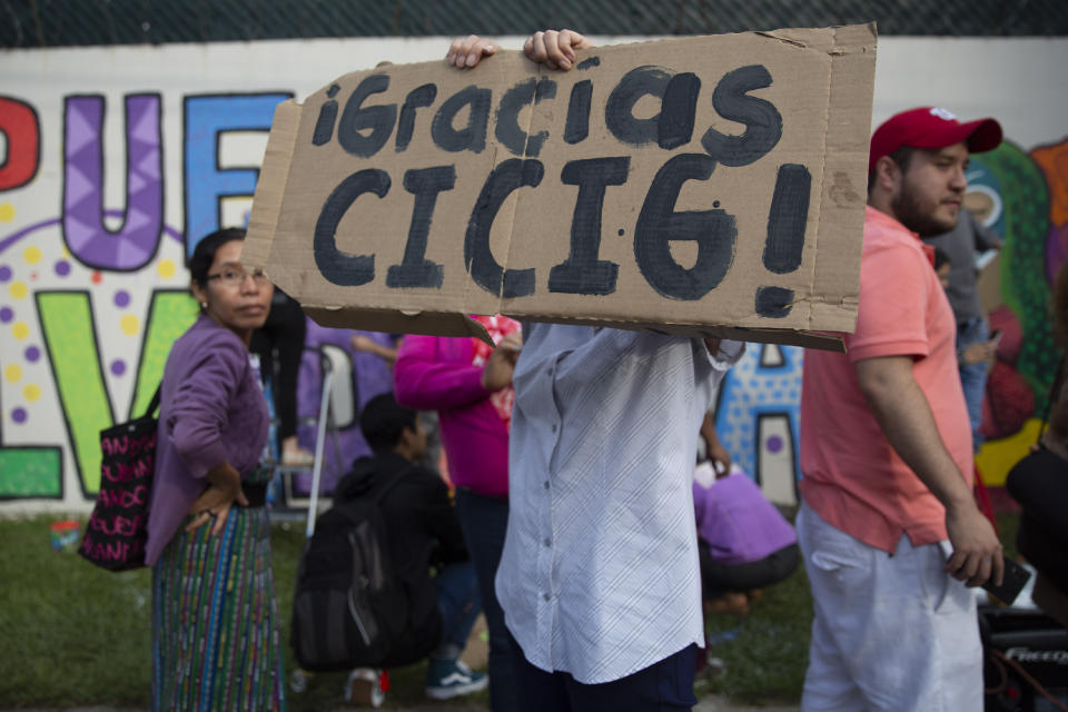 An activist holds a sing that reads in Spanish "Thanks CICIG" at the United Nations International Commission Against Impunity headquarters in Guatemala City, Saturday, Aug. 31, 2019. The UN mission is closing its operation after 12 years. It brought to trial three former presidents and hundreds of businessmen, officials, judges and individuals accused of corruption in the Central American country. (AP Photo/Moises Castillo)
