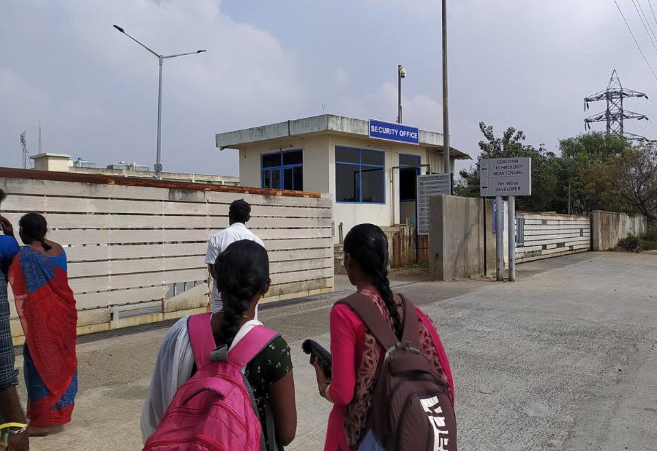 Two unidentified women stand outside Foxconn's factory in Sriperumbudur near Chennai (REUTERS)