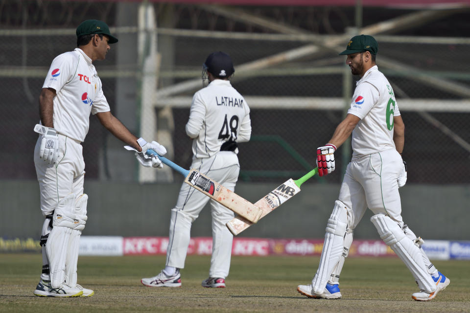 Pakistan's Agha Salman, right, celebrates with teammate Nauman Ali, left, after hitting a boundary during the second day of first test cricket match between Pakistan and New Zealand, in Karachi, Pakistan, Tuesday, Dec. 27, 2022. (AP Photo/Fareed Khan)