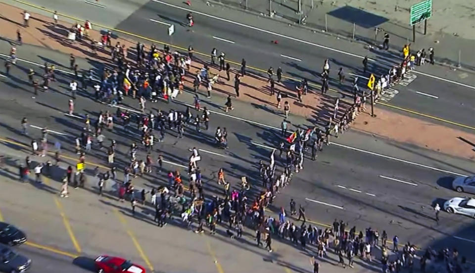 This aerial image provided by KABC-TV shows Black Lives Matter protesters blocking a freeway in downtown Los Angeles on Wednesday, May 27, 2020. Hundreds of people protesting the death of a black man in Minneapolis police custody blocked the freeway and shattered the back window of a California Highway Patrol cruiser on Wednesday. (KABC-TV via AP)