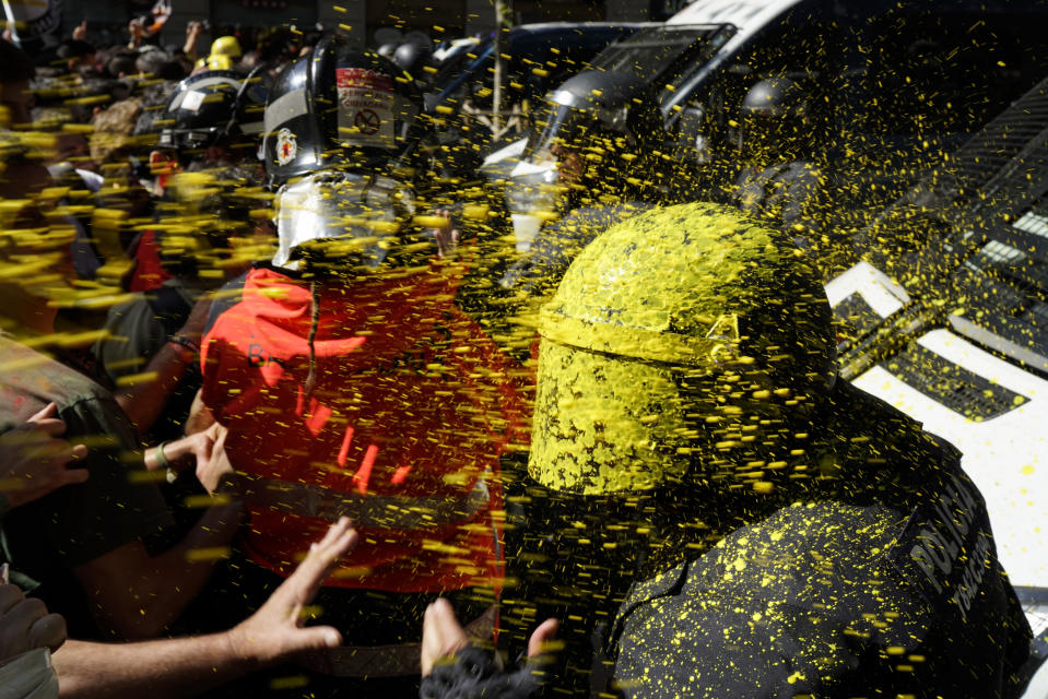 FILE - In this Saturday, Sept. 29, 2018 file photo pro-independence demonstrators throw paint at Catalan police officers during clashes in Barcelona, Spain. (AP Photo/Daniel Cole, File)