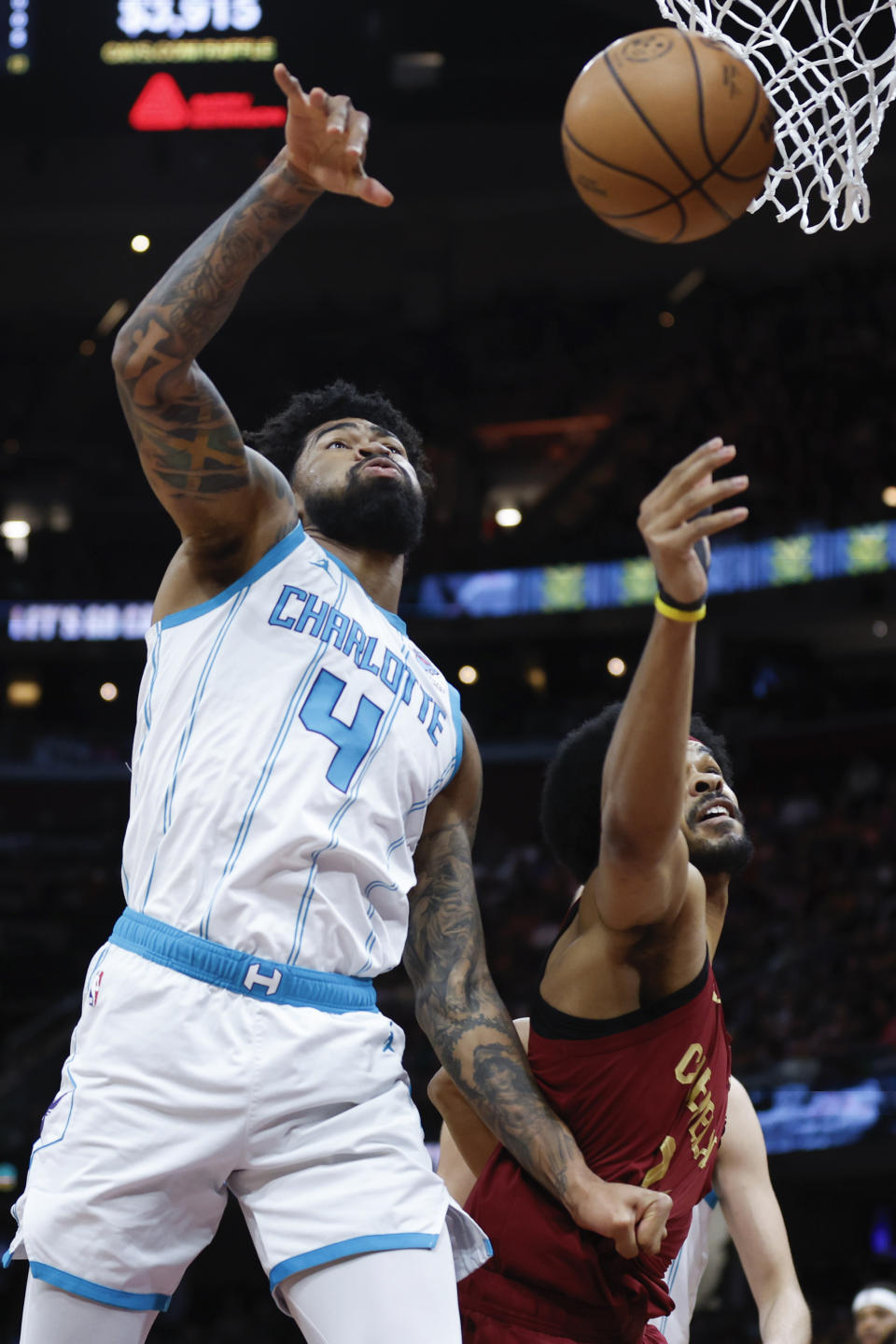 Charlotte Hornets center Nick Richards (4) rebounds against Cleveland Cavaliers center Jarrett Allen during the first half of an NBA basketball game, Monday, March 25, 2024, in Cleveland. (AP Photo/Ron Schwane)