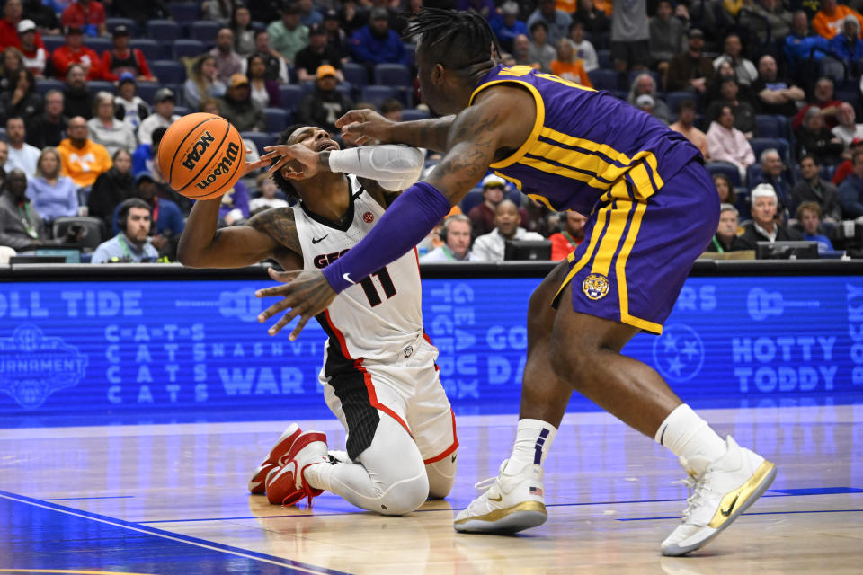 Georgia guard Justin Hill (11) goes to the floor as LSU guard Trae Hannibal (0) applies pressure during the second half of an NCAA college basketball game in the first round of the Southeastern Conference tournament, Wednesday, March 8, 2023, in Nashville, Tenn. LSU won 72-67. (AP Photo/John Amis)