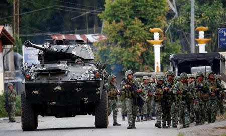 Members of Philippine Marines walk next to an armoured fighting vehicle (AFV) as they advance their position in Marawi City, Philippines May 28, 2017. REUTERS/Erik De Castro