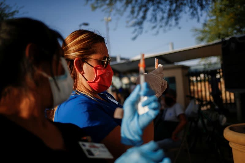 Foto de trabajadores de salud del Departamento de Bomberos de El Paso, Texas, vacunando contra el coronavirus en un centro cerca del Puente Internacional Santa Fe