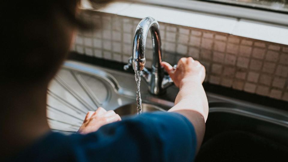 PHOTO: Someone turning the tap on to wash their hands at a kitchen sink in an undated stock photo. (STOCK PHOTO/Getty Images)