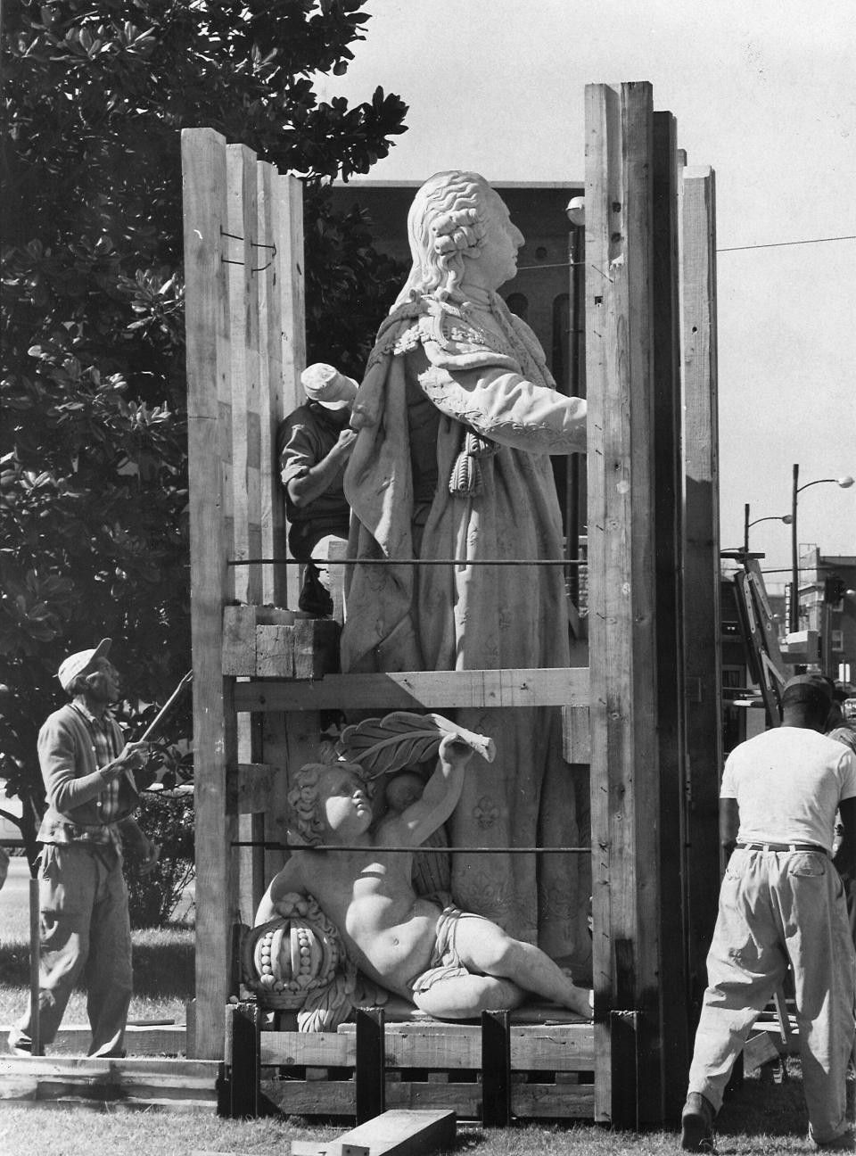 Workers unpack the marble statue of King Louis XVI in July 1967 from a crate following its trip from France.