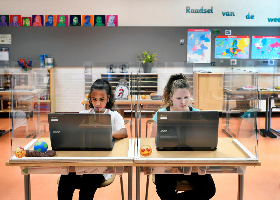 Pupils sit behind partition boards made of plexiglass at a primary school in Den Bosch, Netherlands.