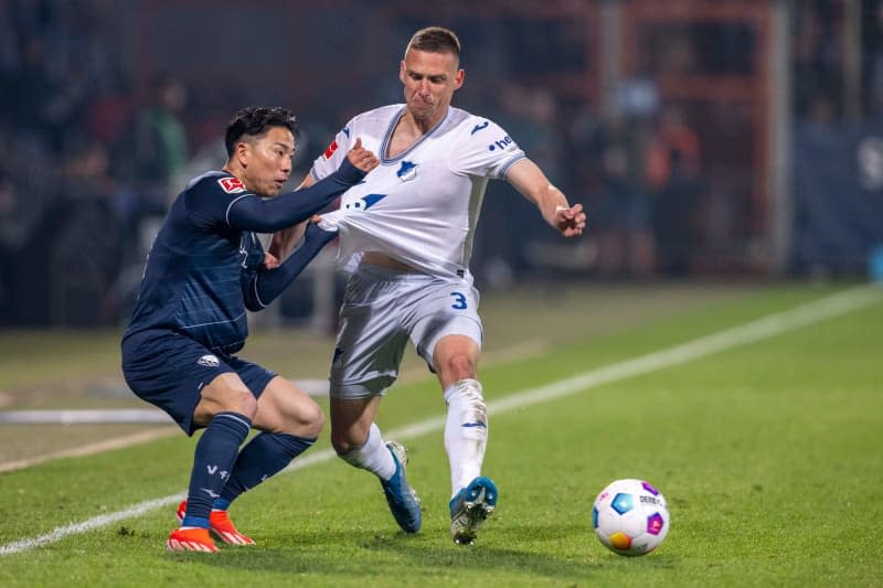 Bochum's Takuma Asano (L) and Hoffenheim's Pavel Kaderabek battle for the ball during the German Bundesliga soccer match between VfL Bochum and TSG 1899 Hoffenheim at the Vonovia Ruhrstadion. David Inderlied/dpa