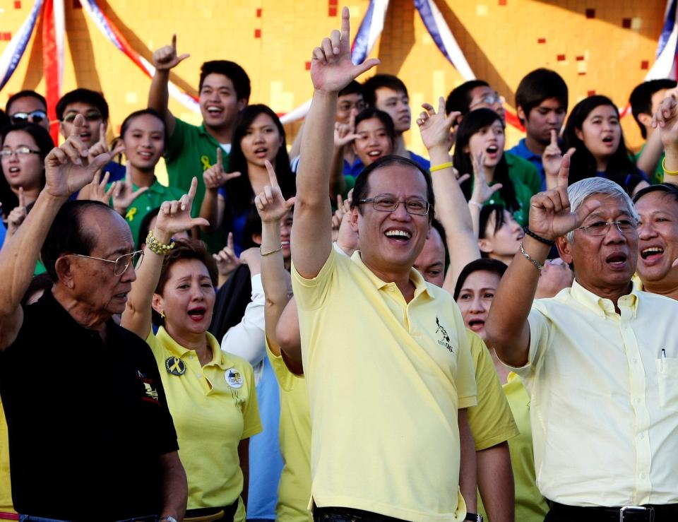 Aquino flashes the 'L' sign (for 'laban', or 'fight') on the 25th anniversary of the 1986 revolution - Bullit Marquez/AP