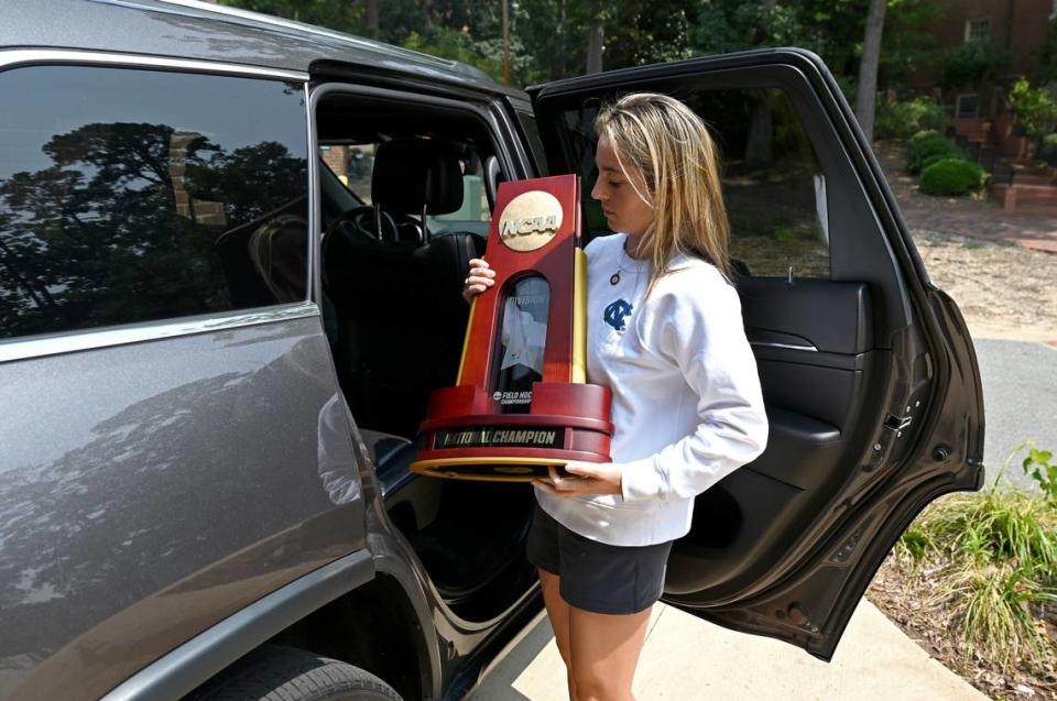 UNC field hockey coach Erin Matson carries the team’s 2022 National Championship trophy to the team facility in Chapel Hill June 29, 2023. Matson was a field hockey standout at Chapel Hill -- a three-time national player of the year and a four-time national champion. She graduated from UNC in December 2022 and then became the team’s head coach in January 2023.