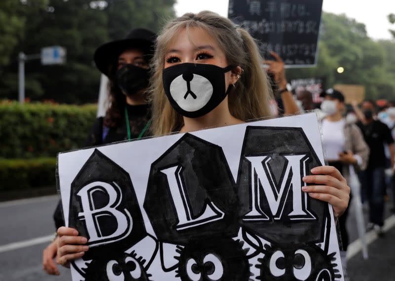 People wearing face masks march during a Black Lives Matter protest following the death in Minneapolis police custody of George Floyd, in Tokyo