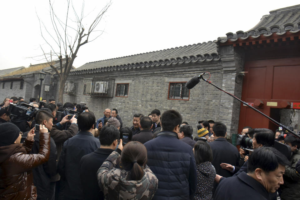 FILE - In this Tuesday Feb. 25, 2014 file photo, Chinese President Xi Jinping, center, is surrounded by onlookers and television crew during an unannounced visit to a residential alley in Beijing. Xi looks more powerful than any Chinese leader in recent decades as his government prepares to deliver its first one-year report card Wednesday, March 5 but a deadly weekend slashing spree by alleged separatists was a reminder of the serious challenges facing his administration. In recent weeks, Xi has put himself in charge of a new top-level party committee focused on steering state security, a panel on driving sweeping economic reforms, and another on cybersecurity. (AP Photo/File) CHINA OUT